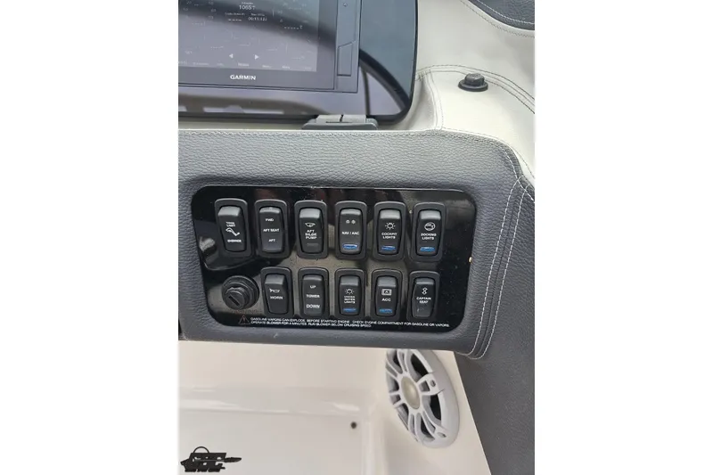 Slide: The Image of Control panel of a 2021 Regal LX4 boat with various switches and a Garmin display. - 67