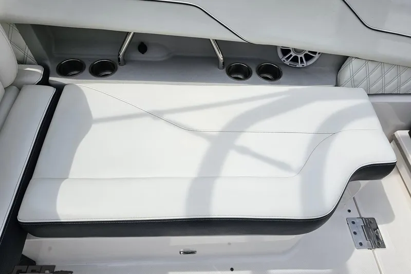 Slide: The Image of 2021 Regal LX4 boat interior with white cushioned seating and cup holders. - 89