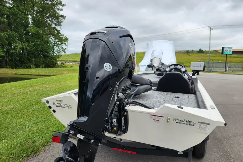 Slide: The Image of 2024 Tracker Pro Team 175 TXW boat with powerful outboard motor, parked outdoors. - 3