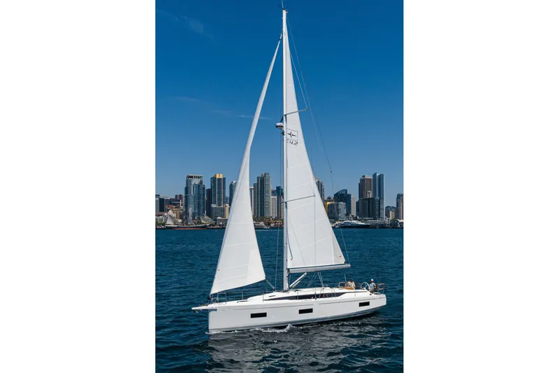 Slide: The Image of 2023 Bavaria C42 sailboat cruising near city skyline under clear blue sky. - 10