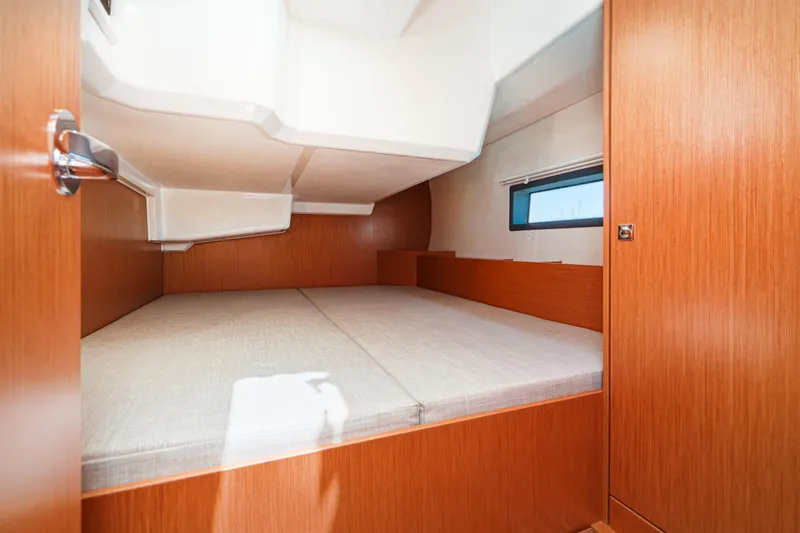 Slide: The Image of 2023 Bavaria C42 yacht cabin interior with wooden finish and comfortable bedding. - 50