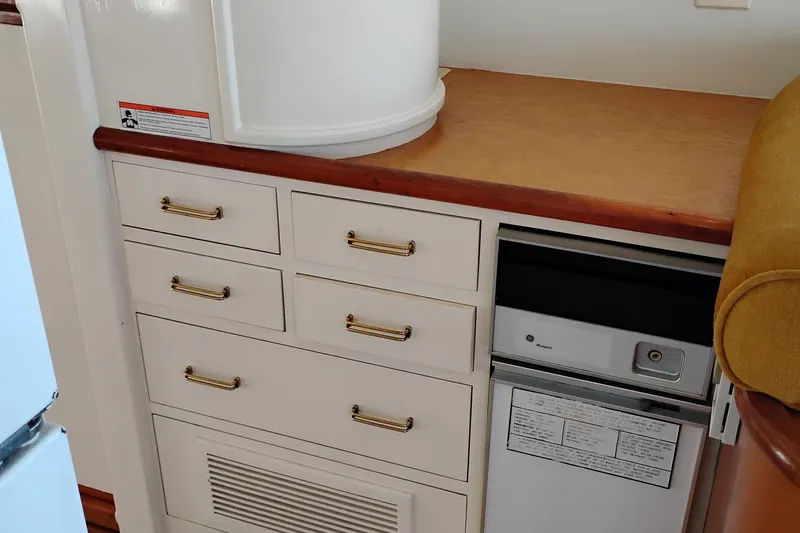 Slide: The Image of 1995 Queenship 62 Pilothouse Motor Yacht interior with drawers and built-in refrigerator. - 19