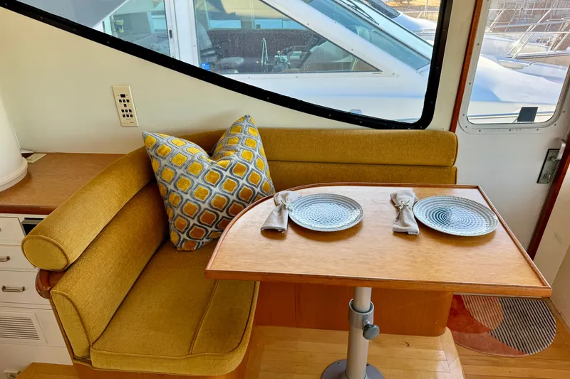 Slide: The Image of Cozy dining area in 1995 Queenship 62 Pilothouse Motor Yacht with yellow seating and decorative pillows. - 20