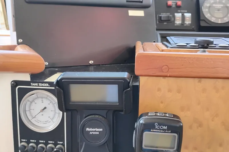 Slide: The Image of Control panel of a 1995 Queenship 62 Pilothouse Motor Yacht with various gauges and devices. - 26