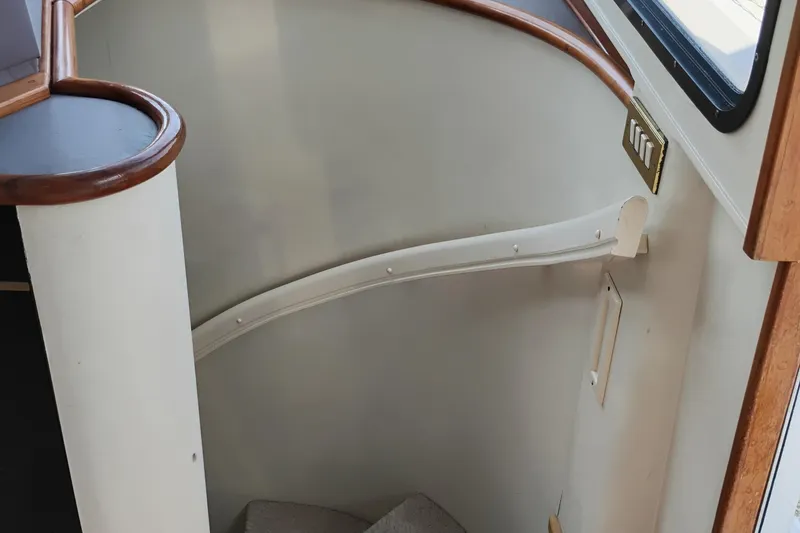 Slide: The Image of Staircase inside 1995 Queenship 62 Pilothouse Motor Yacht with wooden handrails and window. - 29