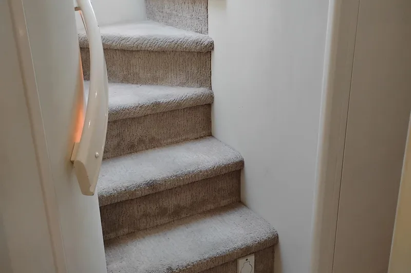 Slide: The Image of Carpeted stairs inside a 1995 Queenship 62 Pilothouse Motor Yacht. - 30