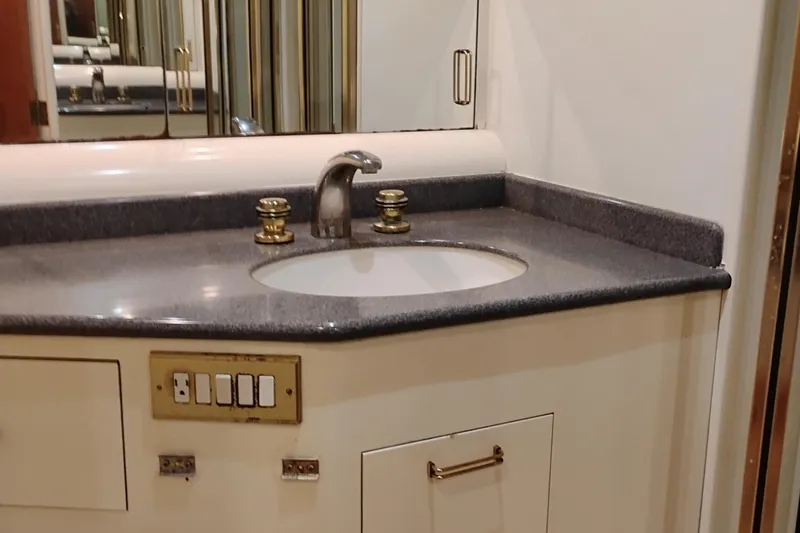 Slide: The Image of Bathroom sink area in 1995 Queenship 62 Pilothouse Motor Yacht, featuring modern fixtures. - 39