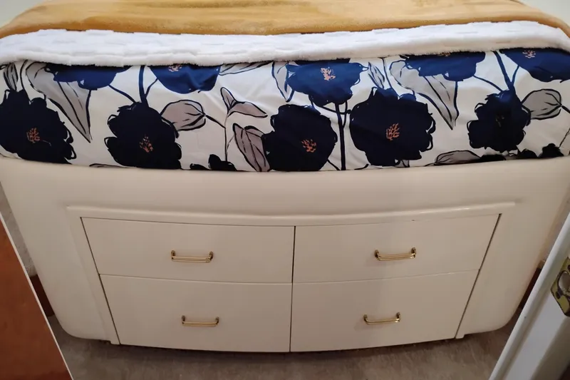 Slide: The Image of Queenship 62 Pilothouse Motor Yacht 1995 interior with floral bedding and storage drawers. - 44