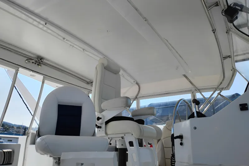 Slide: The Image of Interior view of 1995 Queenship 62 Pilothouse Motor Yacht helm with white seating. - 49