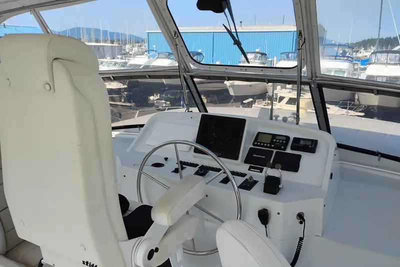 Slide: The Image of Pilothouse of 1995 Queenship 62 Motor Yacht with steering wheel and navigation controls. - 50