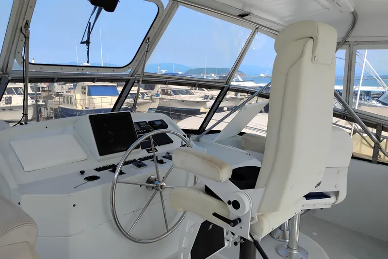 Slide: The Image of Pilothouse interior of 1995 Queenship 62 Motor Yacht with steering wheel and control panel. - 52