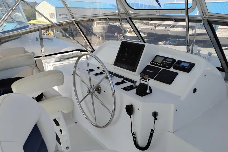 Slide: The Image of Pilothouse of 1995 Queenship 62 Motor Yacht with steering wheel and navigation controls. - 53