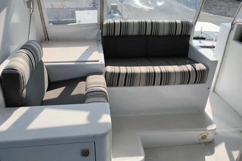 Slide: The Image of Interior seating area of 1995 Queenship 62 Pilothouse Motor Yacht with striped cushions. - 56