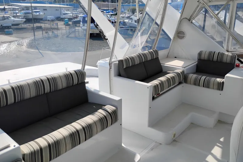 Slide: The Image of Luxurious seating area on 1995 Queenship 62 Pilothouse Motor Yacht, docked at marina. - 57