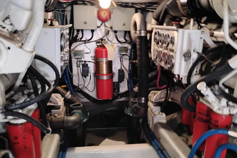 Slide: The Image of Engine room of 1995 Queenship 62 Pilothouse Motor Yacht with visible machinery and fire extinguisher. - 68