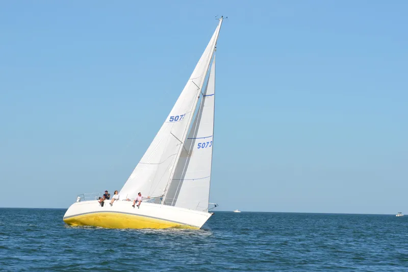 Slide: The Image of 1989 Beneteau First 41S5 sailboat with yellow hull sailing on open water. - 35