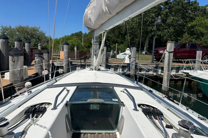 Slide: The Image of Sailboat Beneteau First 41s5, 1989 model, docked at a marina with clear blue skies. - 17