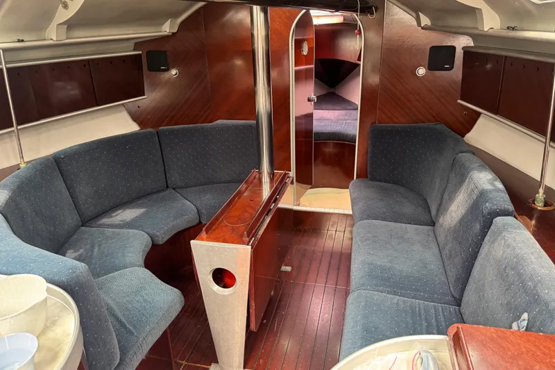 Slide: The Image of Interior of 1989 Beneteau First 41s5 yacht with blue seating and wooden finishes. - 22