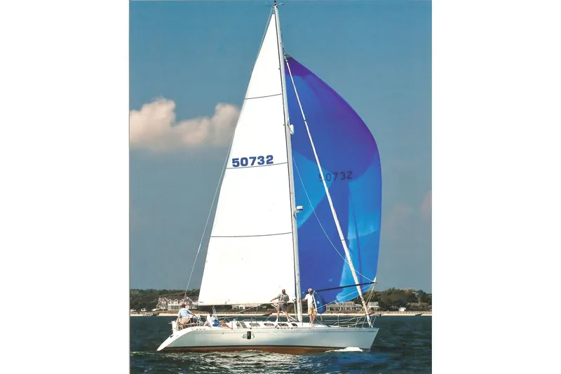 Slide: The Image of 1989 Beneteau First 41S5 sailboat with blue and white sails on open water. - 40