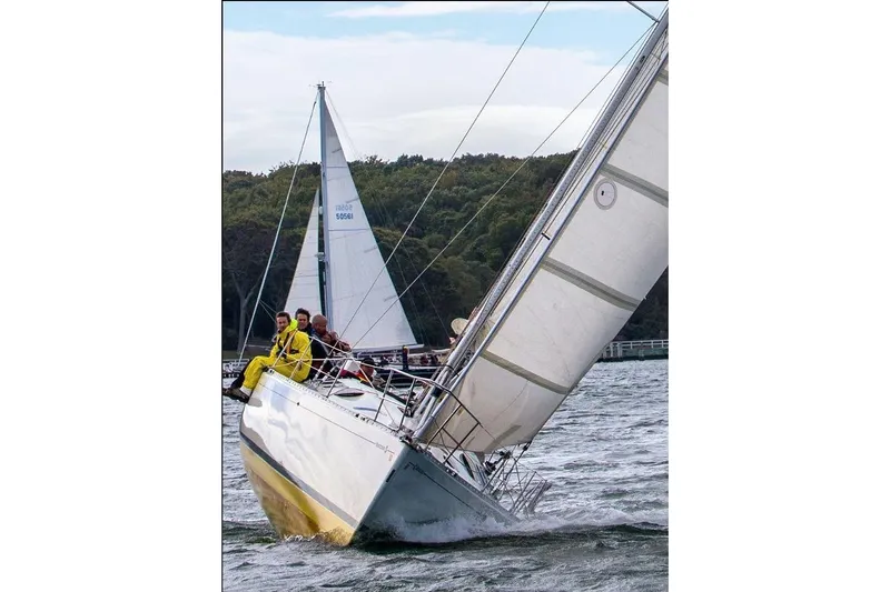 Slide: The Image of Sailing on a 1989 Beneteau First 41S5 yacht with crew in vibrant gear. - 41
