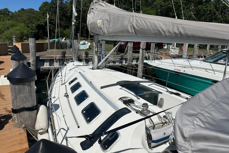 Slide: The Image of 1989 Beneteau First 41s5 sailboat docked at a marina, showcasing sleek design and rigging. - 11
