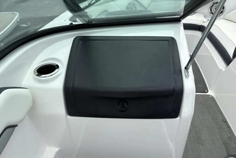 Slide: The Image of 2017 Yamaha Boats SX195 interior dashboard with cup holder and storage compartment. - 19