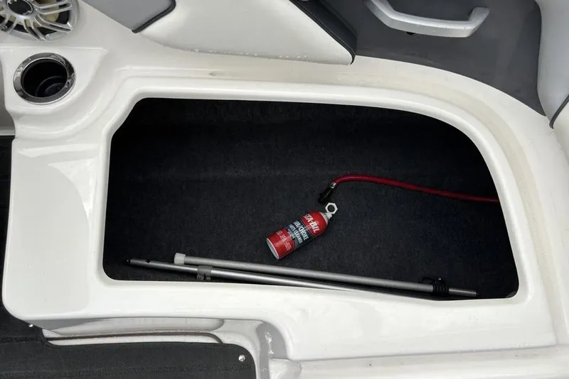 Slide: The Image of Storage compartment in a 2017 Yamaha SX195 boat with a fire extinguisher and pole. - 27