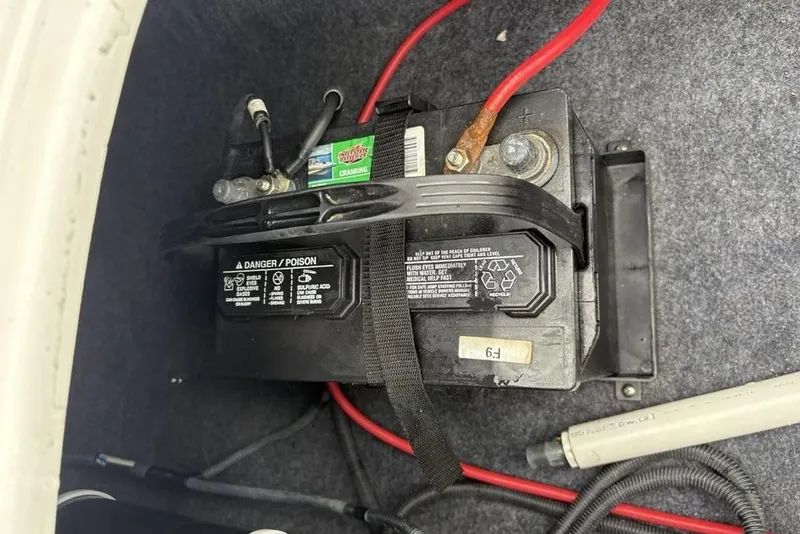Slide: The Image of Battery compartment of a 2017 Yamaha Boats SX195 with visible wiring and safety labels. - 28