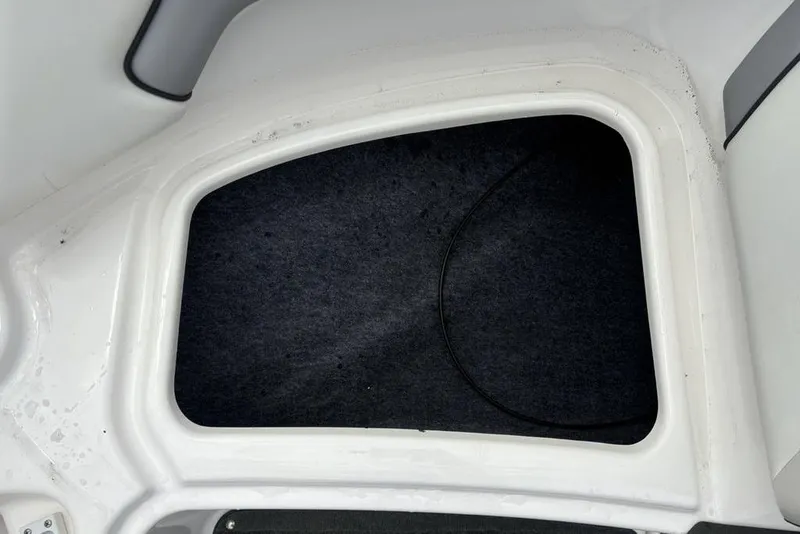 Slide: The Image of Storage compartment of a 2017 Yamaha Boats SX195, featuring a clean, carpeted interior. - 7