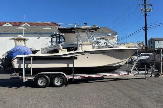 Slide: The Image of 2005 Grady-White Advance 257 boat docked in a marina with waterfront homes. - 2