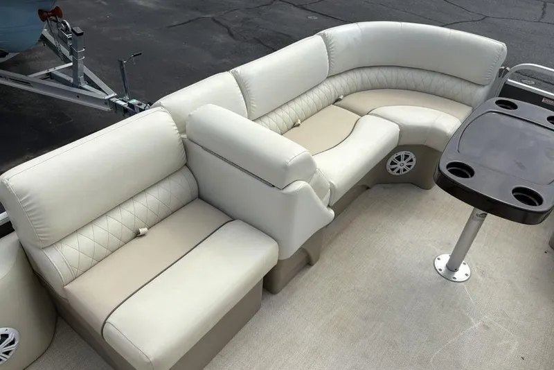 Slide: The Image of 2015 Bennington 24 S Series pontoon boat interior with plush seating and table. - 10