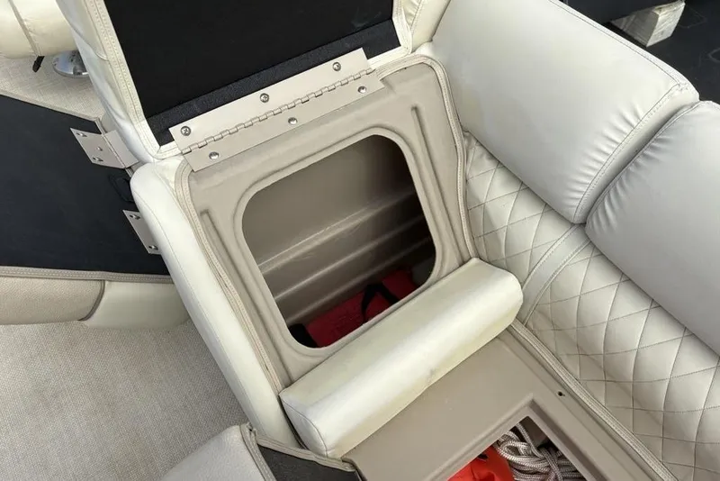 Slide: The Image of 2015 Bennington 24 S Series boat seat storage compartment with quilted upholstery. - 13