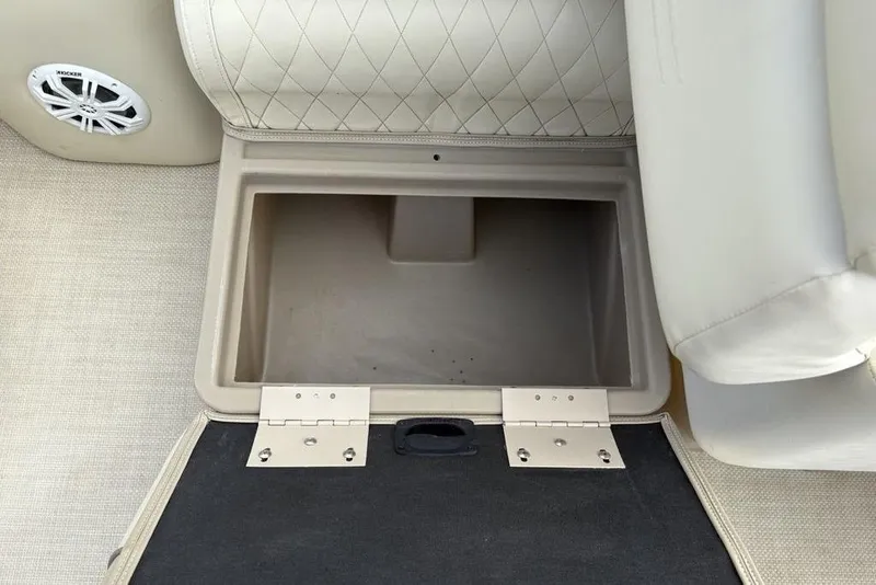 Slide: The Image of Open storage compartment in 2015 Bennington 24 S Series boat with beige upholstery. - 14