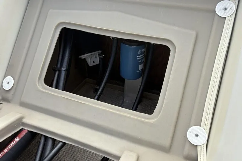 Slide: The Image of 2015 Bennington 24 S Series boat compartment with visible wiring and filter. - 24