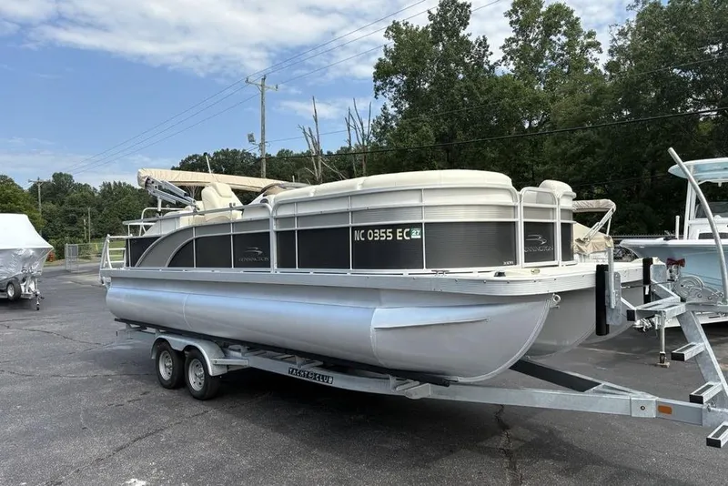 Slide: The Image of 2015 Bennington 24 S Series pontoon boat on trailer, parked outdoors. - 3