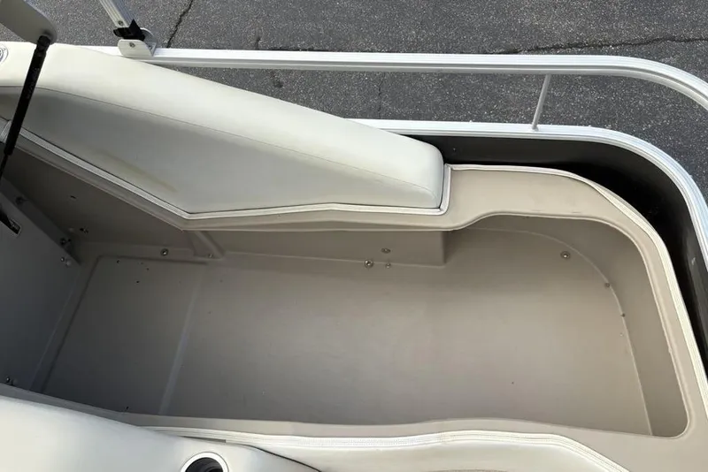 Slide: The Image of Interior view of a 2015 Bennington 24 S Series boat, featuring beige seating and flooring. - 31