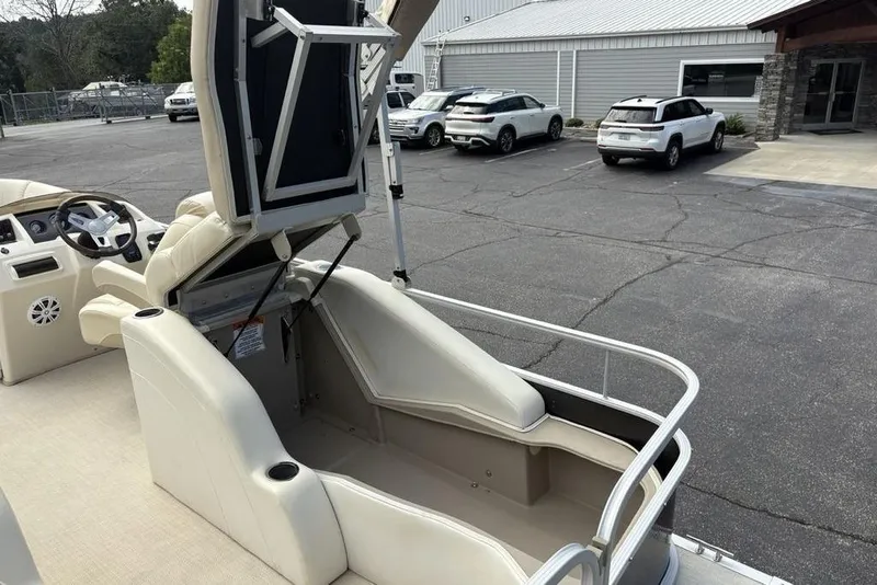 Slide: The Image of 2015 Bennington 24 S Series boat interior with open storage compartment and steering console. - 32