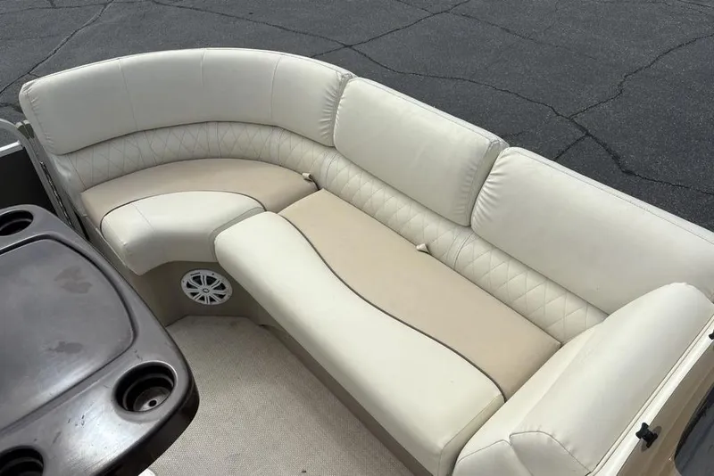 Slide: The Image of 2015 Bennington 24 S Series boat interior with beige seating and cup holders. - 4