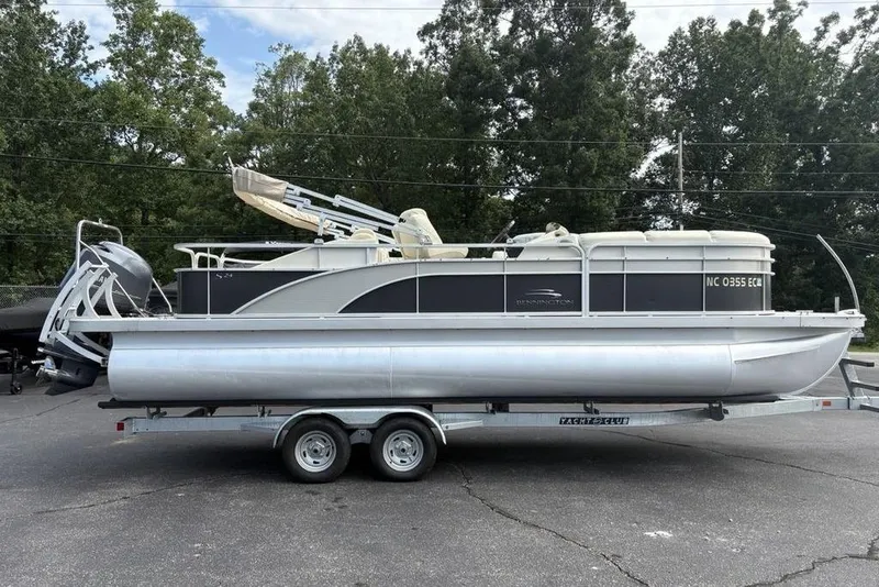 Slide: The Image of 2015 Bennington 24 S Series pontoon boat on trailer, parked outdoors. - 5