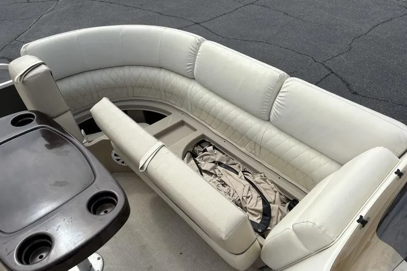 Slide: The Image of 2015 Bennington 24 S Series boat interior with beige seating and storage compartment. - 7