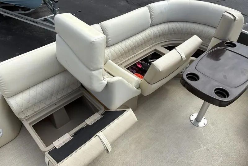 Slide: The Image of 2015 Bennington 24 S Series boat interior with beige seating and storage compartments. - 9