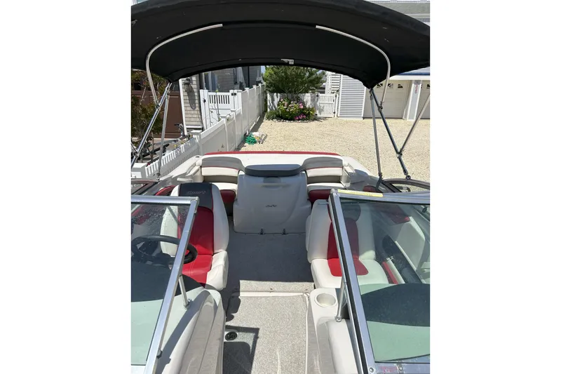 Slide: The Image of 2007 Sea Ray 205 Sport boat interior with red and white seating, under a black canopy. - 3