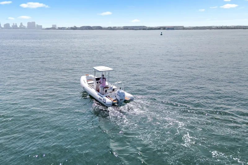 Slide: The Image of 2026 Tide Craft Galveston 19 boat cruising on open water, city skyline in background. - 4