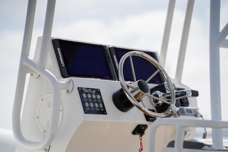 Slide: The Image of Control panel of 2026 Tide Craft Galveston 19 boat with steering wheel and navigation screens. - 9