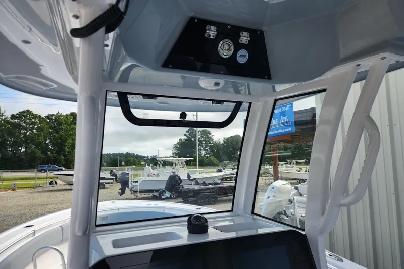 Slide: The Image of 2026 Sportsman Open 252 Center Console boat interior with view of marina and parked boats. - 7