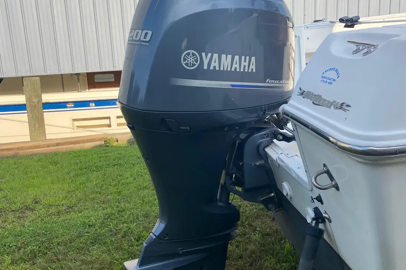 Slide: The Image of 2002 Wellcraft 24 Coastal Walkaround with Yamaha outboard motor, parked on grass. - 2