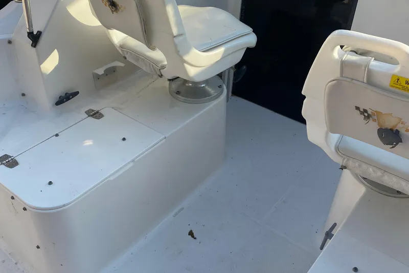 Slide: The Image of 2002 Wellcraft 24 Coastal Walkaround boat interior with white seating and storage compartments. - 4