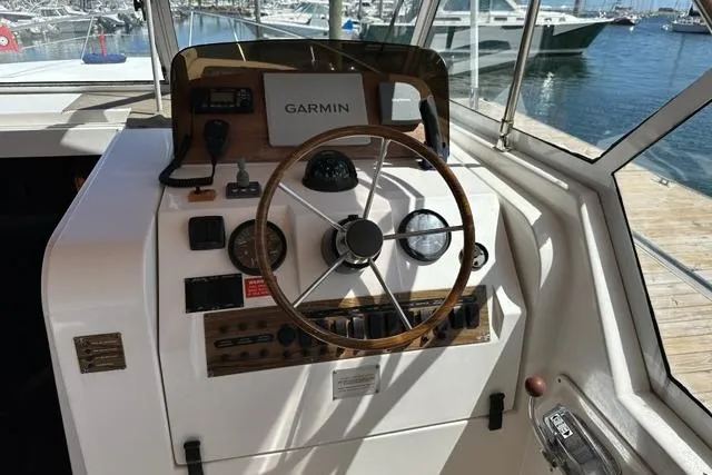 Slide: The Image of 2002 Mainship Pilot 34 helm with Garmin navigation, docked at marina. - 11