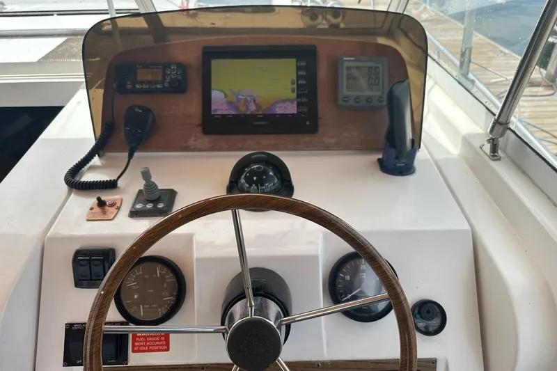 Slide: The Image of 2002 Mainship Pilot 34 helm with steering wheel, navigation instruments, and control panel. - 12