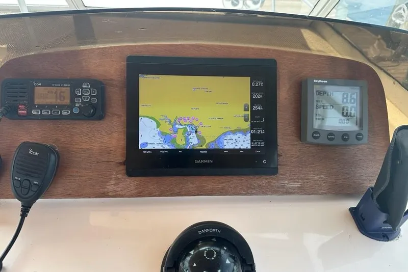 Slide: The Image of 2002 Mainship Pilot 34 dashboard with Garmin navigation, Icom radio, and Raytheon depth display. - 13